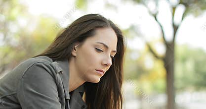 Sad pensive woman sitting in a park