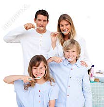 Smiling family brushing their teeth in the b