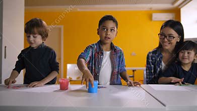 Diverse kids hand painting with watercolors at class