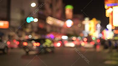 Blurred view of the night street with illuminated red lights in Chinatown at Bangkok