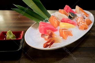 Mixed sliced fish sashimi on ice in white bowl. Sashimi Salmon Tuna Hamachi Prawn and Surf Calm set, raw fish, japanese food in