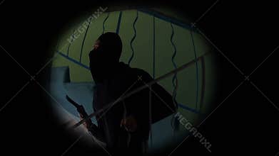 Nervous masked criminal running away after burglary, looking at pistol, doorhole