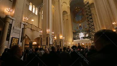 People praying on liturgy in Holy Trinity Cathedral in Tbilisi, Christian faith