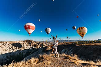 Couple in love among the balloons meets the sun