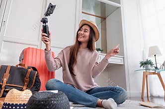 Asian young female blogger recording vlog video with mobile phone live streaming when travel.online influencer on social media vi