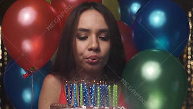 Birthday. Woman Blowing Candles On Cake With Balloons At Party