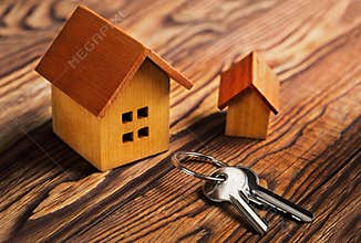 Real estate concept with house and key on wooden background. Idea for real estate concept, personal property an