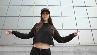 Female dancer performs modern hip-hop dance, posing, contemporary freestyle in the street, urban