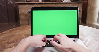 POV shot of person working on a modern laptop with green screen