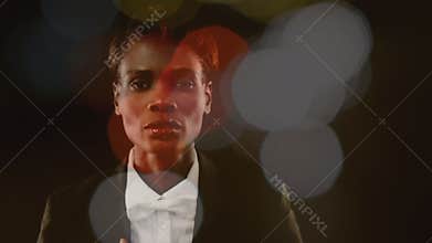 Businesswoman looking at camera surrounded by bokeh effect