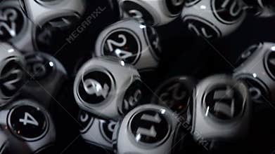 Black and white lottery balls in a machine slow motion