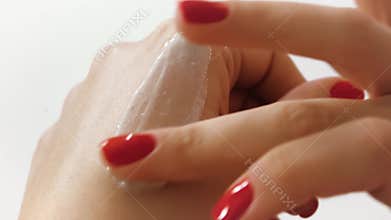 Applying hand cream, skin care on a white background