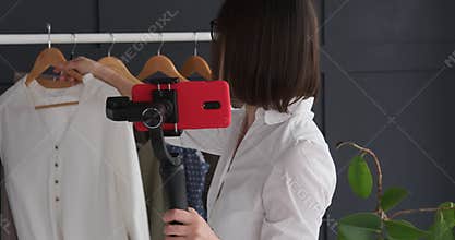 Fashion vlogger recording a video of trendy outfit and accessory