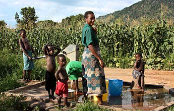 Mother and sons by a fountain in Africa