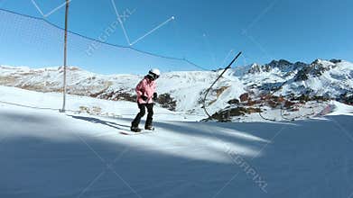 Young hipster female snowboarder on sunny slope