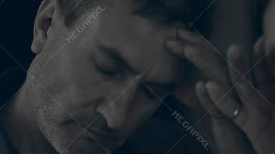 Close up of a man looking in the mirror being lonely and depressed. The concept of alcoholism, addiction, difficult life