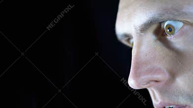 Look of Fear, Bulging Eyes of a Young Man on a Black Background