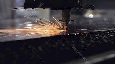 The CNC laser cut machine while cutting the sheet metal with the sparking light.The hi-precision sheet cutting process