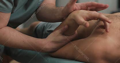 Physiotherapist doing healing treatment on man`s arm. Alternative medicine treatment and rehabilitation of patients