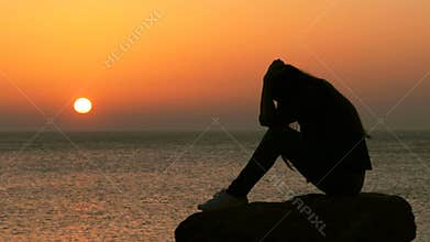 Sad woman complaining at sunset on the beach