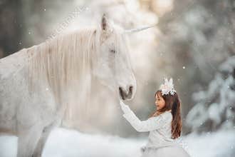 The little princess with an unicorn in the forest.