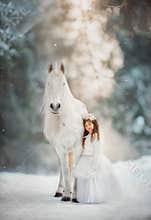 The little princess with an unicorn in the forest.