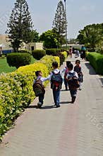 Pakistani schoolchildren with backpacks and uniforms walk towards classes Karachi Pakistan