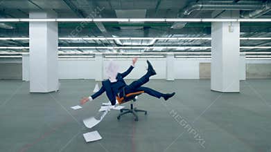 Happy office worker throws paper in the air while sitting in a chair.