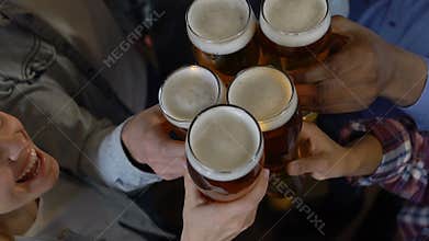 Happy friends clinking beer glasses in pub, evening entertainment after work
