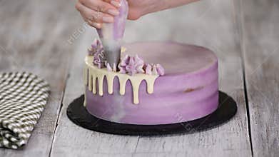 Chef Decorating Cake with a cream.