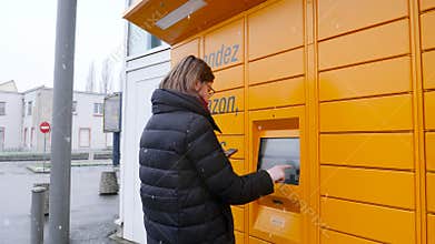 Woman using smartphone near Amazon Locker from bottom to top