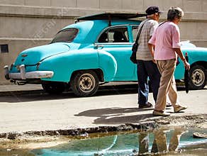 old couple in front of an old car