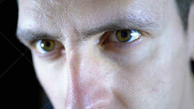 Close-up of the eyes and face of a young man working at a computer on a Black Background
