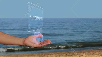 Male hands on the beach hold a conceptual hologram with the text Automation