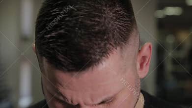 Fat man weighs himself on scales and is surprised.