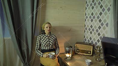 Tired tailor girl have a rest, drinks tea, relaxes, listens music on vinyl plate, gramophone or phonograph. Retro