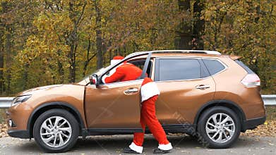 Santa Claus is pushing broken down car in the forest 50 fps