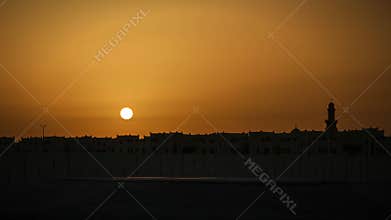 Sunset Timel-apse. Minaret silhouette of a Mosque in frame. Bahrain