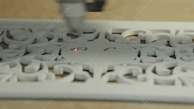 Close-up, a machine for laser engraving of a drawing on a wooden workpiece.