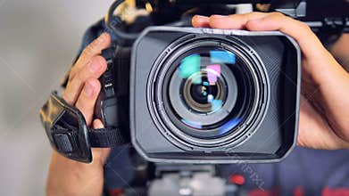 Close-up view on a video camera moved by male hands.