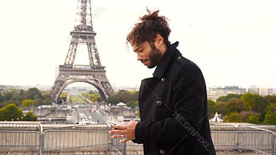 Brazilian male model calling photographer close to Eiffel Tower in slow motion.