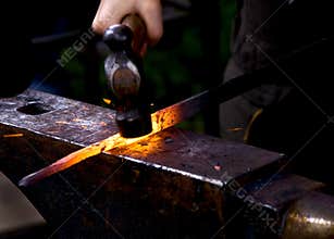 Blacksmith hammering hot metal