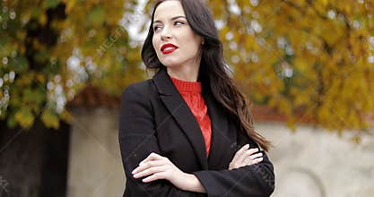Woman with vivid makeup and crossed arms