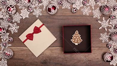 Hands opening christmas present containing a gingerbread cookie