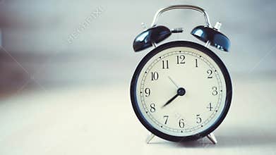 Time lapse vintage background with retro alarm clock on table