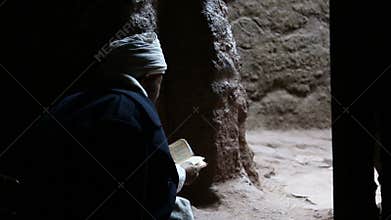 Ethiopia, Lalibela, January 2015, monk reads a book