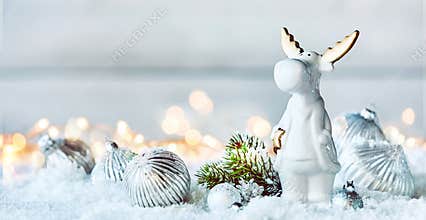 Cute little white Christmas reindeer in snow