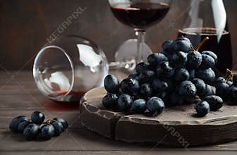 Fresh Black Grapes and Red Wine on Wooden Table