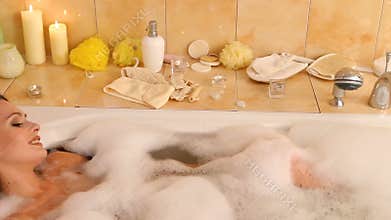 Bubble bath for woman taking , blow on foam . Dolly system.