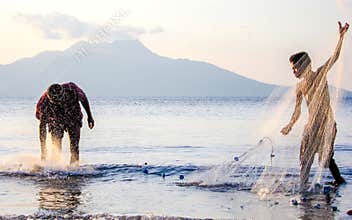 Fishing nets in the sunset, local Fisherman and young apprentice, Flores, Indo, Asia